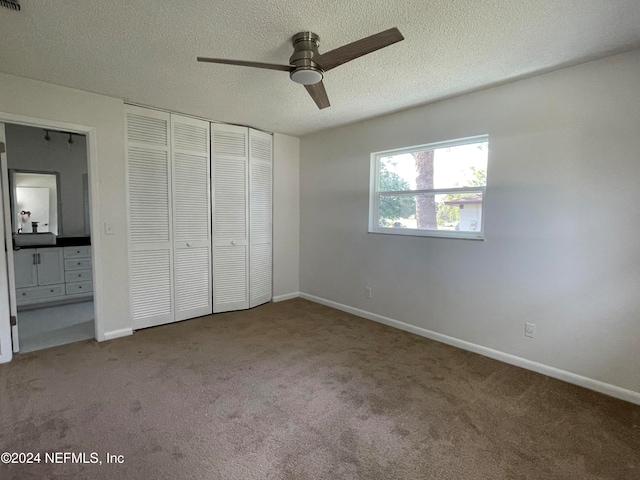 unfurnished bedroom with ceiling fan, carpet floors, a textured ceiling, and a closet