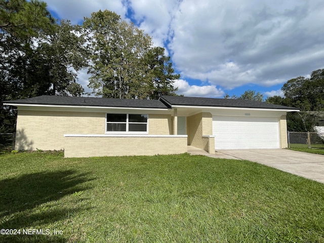 single story home featuring a garage and a front yard