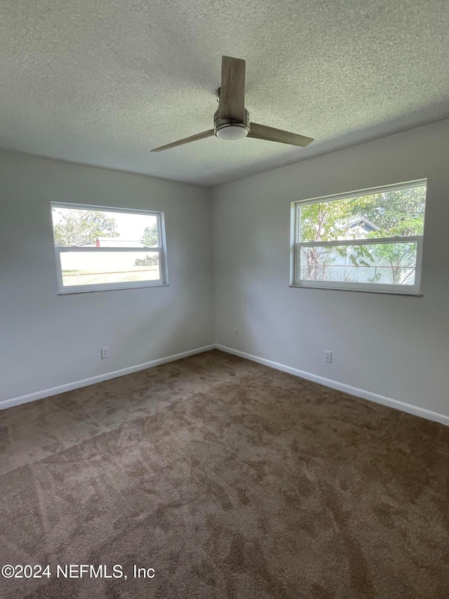 spare room featuring ceiling fan, carpet, and a textured ceiling