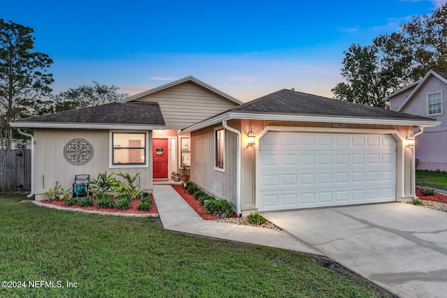 ranch-style home with a garage and a lawn