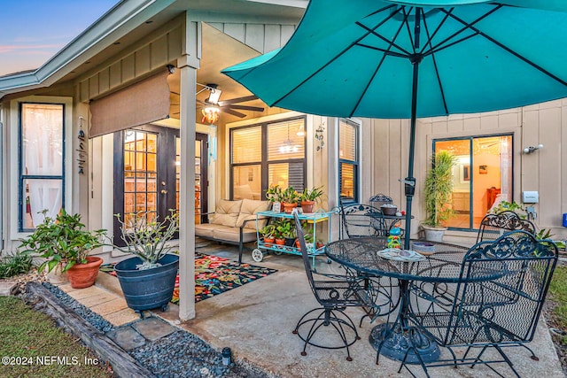 patio terrace at dusk featuring ceiling fan