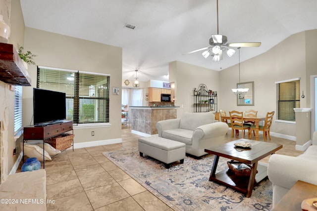 tiled living room featuring high vaulted ceiling and ceiling fan with notable chandelier