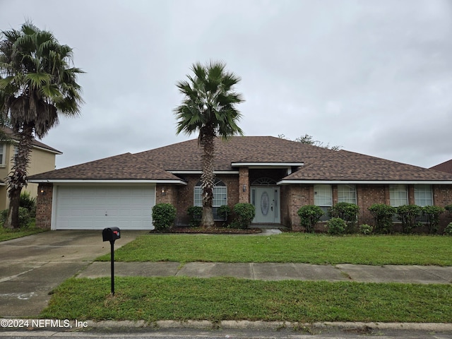 single story home featuring a front lawn and a garage