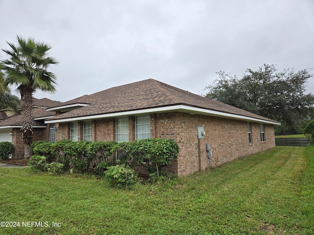 view of side of home with a lawn