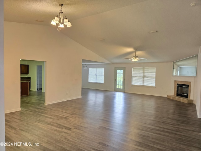 unfurnished living room featuring a textured ceiling, ceiling fan with notable chandelier, dark wood-type flooring, high vaulted ceiling, and a tiled fireplace