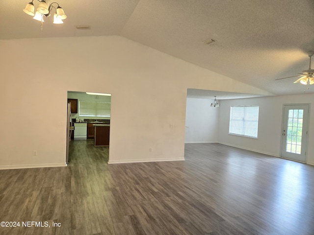 empty room featuring a textured ceiling, ceiling fan with notable chandelier, vaulted ceiling, and dark wood-type flooring