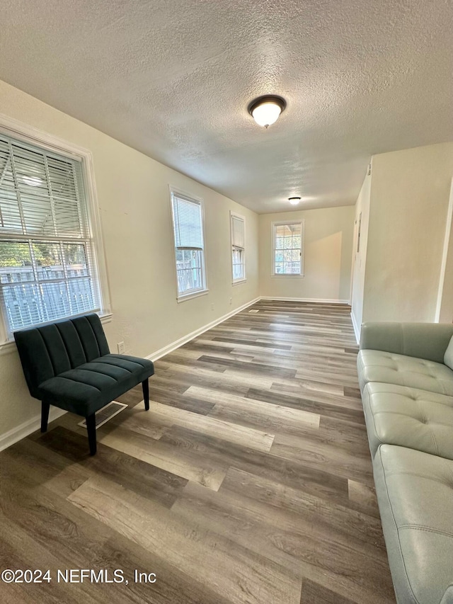 living area with a textured ceiling and hardwood / wood-style flooring