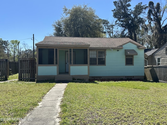 bungalow-style home with crawl space, fence, a front yard, and a sunroom