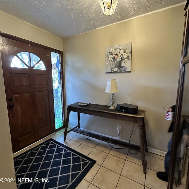 tiled entryway with a textured ceiling