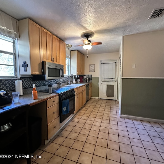 kitchen featuring ceiling fan, sink, tasteful backsplash, a textured ceiling, and appliances with stainless steel finishes