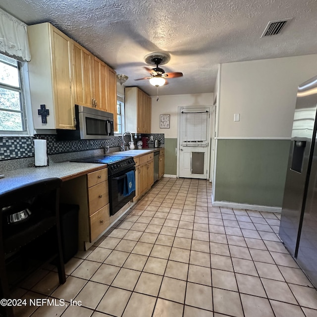 kitchen featuring ceiling fan, sink, backsplash, a textured ceiling, and appliances with stainless steel finishes