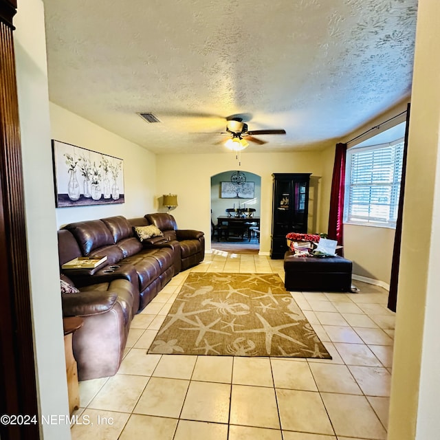 tiled living room featuring a textured ceiling and ceiling fan