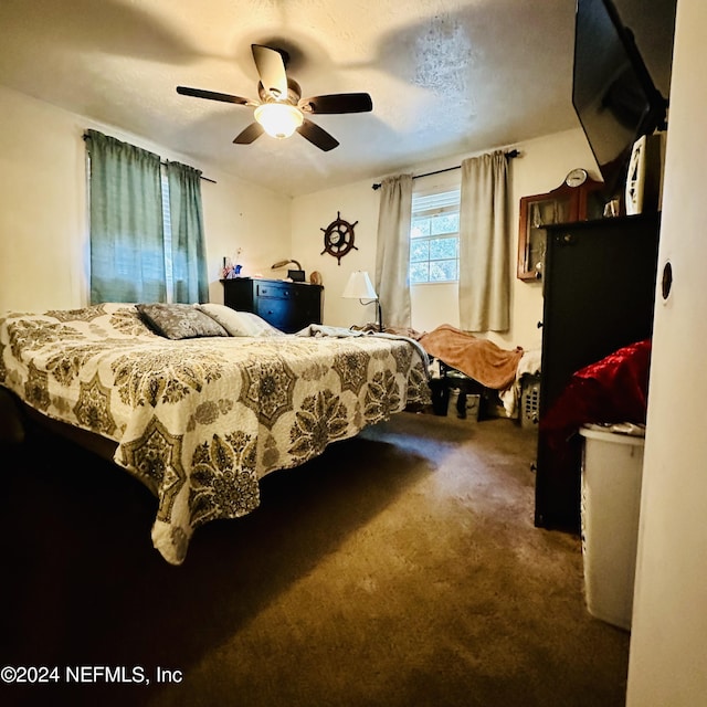 carpeted bedroom featuring a textured ceiling and ceiling fan