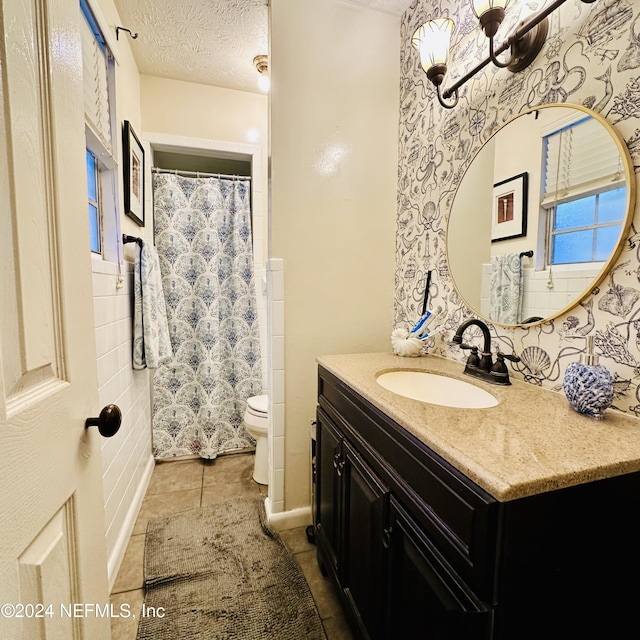 bathroom featuring toilet, a textured ceiling, vanity, and tile patterned floors