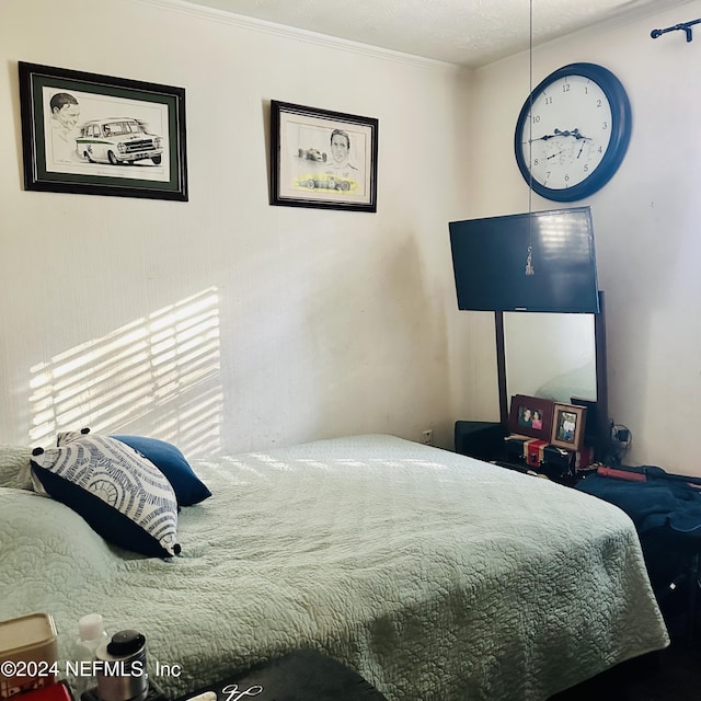 bedroom with a textured ceiling and ornamental molding