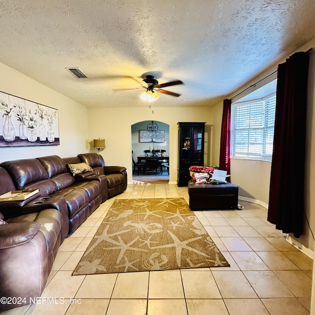 tiled living room featuring ceiling fan and a textured ceiling