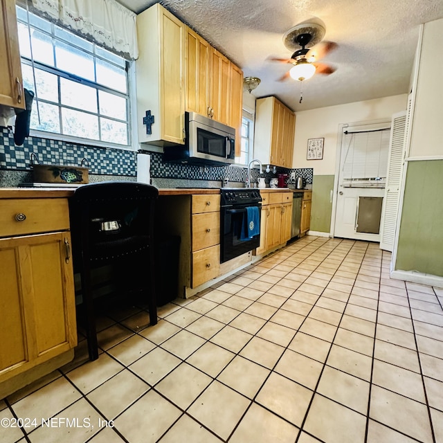 kitchen featuring decorative backsplash, ceiling fan, stainless steel appliances, and a textured ceiling