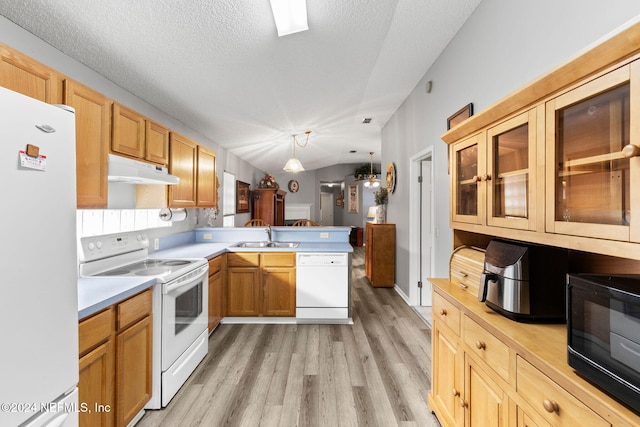 kitchen with kitchen peninsula, white appliances, vaulted ceiling, pendant lighting, and light hardwood / wood-style flooring