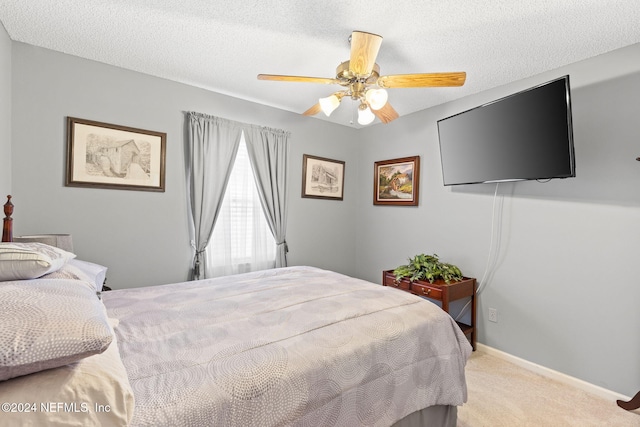 bedroom featuring ceiling fan, light colored carpet, and a textured ceiling