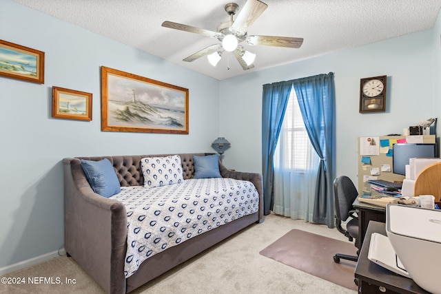 bedroom featuring a textured ceiling, ceiling fan, and light carpet