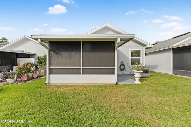 view of side of property featuring central air condition unit, a sunroom, and a yard