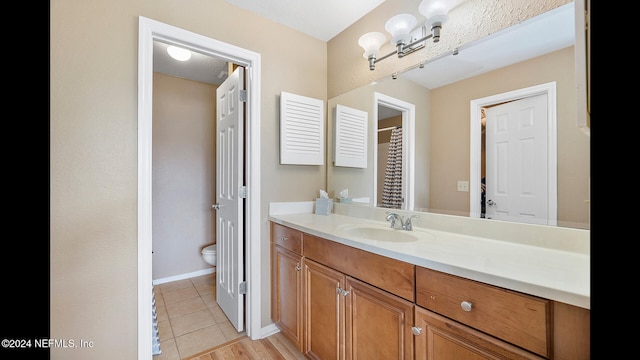 bathroom featuring tile patterned flooring, vanity, and toilet