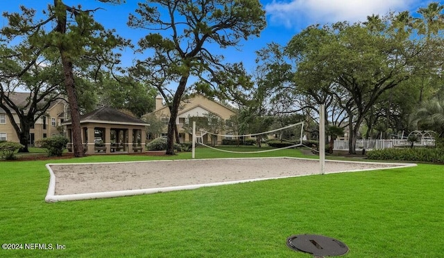 view of property's community with volleyball court, a gazebo, and a yard