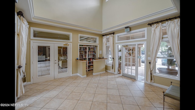 doorway to outside featuring built in features, light tile patterned floors, a towering ceiling, and french doors