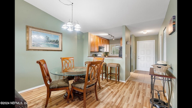 dining area featuring light hardwood / wood-style floors and a chandelier