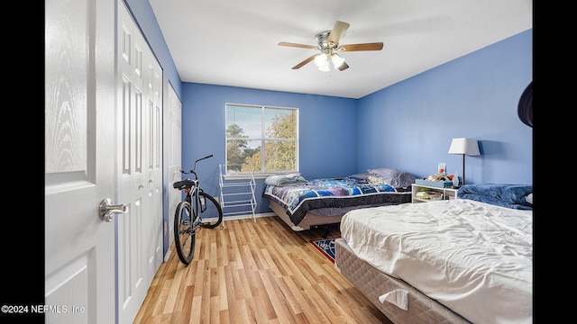 bedroom with ceiling fan, a closet, and light hardwood / wood-style flooring