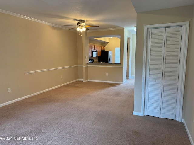 unfurnished living room featuring ceiling fan, light colored carpet, and crown molding