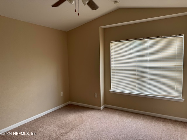 carpeted empty room featuring vaulted ceiling and ceiling fan