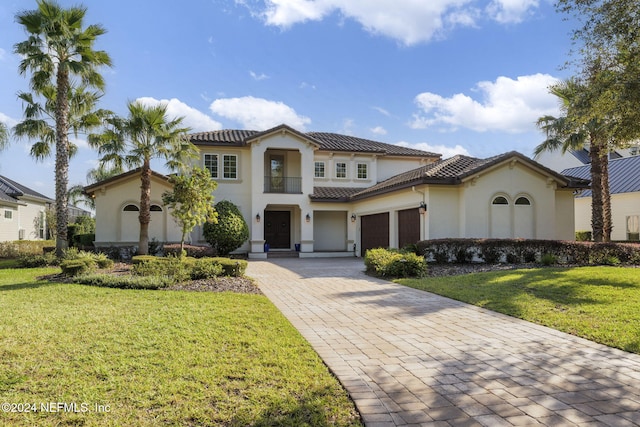 mediterranean / spanish-style home with a garage and a front lawn