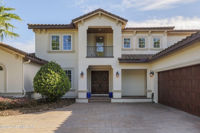 mediterranean / spanish-style home with a balcony and a garage