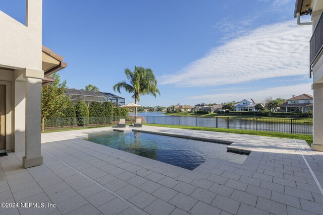 view of swimming pool featuring a water view and a patio