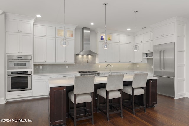 kitchen with dark hardwood / wood-style floors, wall chimney exhaust hood, and an island with sink