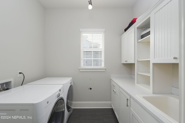 clothes washing area with cabinets and washing machine and clothes dryer