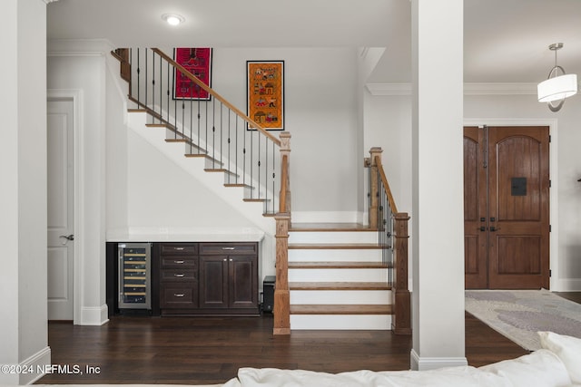 staircase with wood-type flooring, wine cooler, and ornamental molding