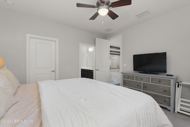 bedroom with carpet flooring, ceiling fan, and ensuite bath