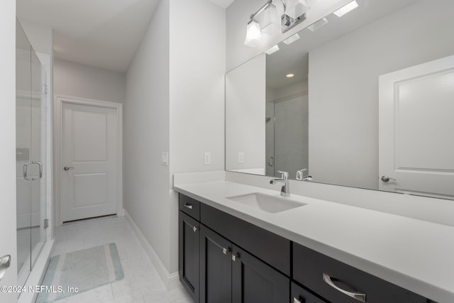 bathroom featuring tile patterned flooring, vanity, and a shower with shower door