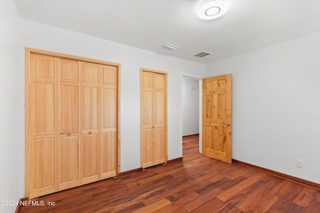 unfurnished bedroom with dark wood-type flooring