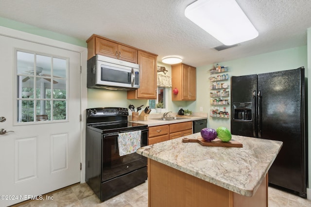 kitchen featuring black appliances, sink, a textured ceiling, a kitchen island, and light stone counters