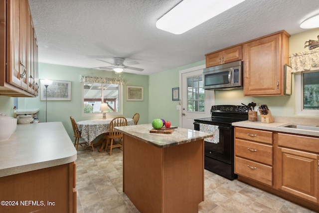 kitchen with a textured ceiling, black range with electric cooktop, and a kitchen island