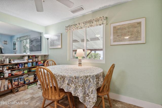 dining room with ceiling fan and a textured ceiling