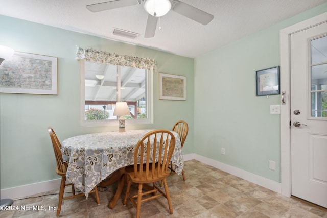 dining area with ceiling fan and a textured ceiling