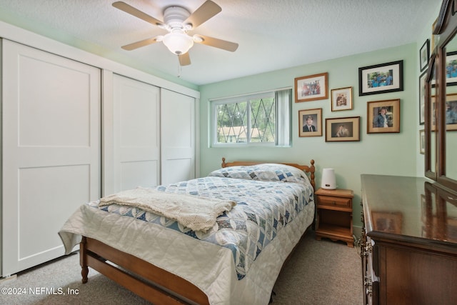 bedroom featuring a textured ceiling, carpet floors, a closet, and ceiling fan