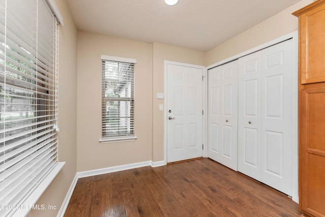 foyer featuring a textured ceiling and dark wood-type flooring