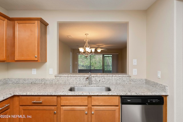 kitchen featuring light stone counters, dishwasher, ceiling fan with notable chandelier, and sink