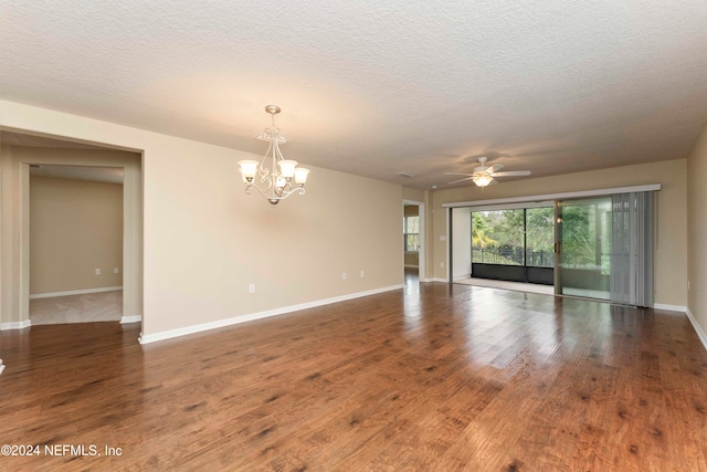 spare room with ceiling fan with notable chandelier, a textured ceiling, and dark hardwood / wood-style flooring