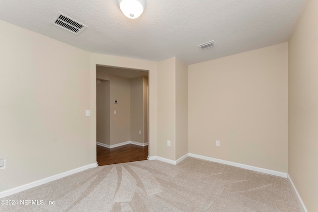 unfurnished room with light carpet and a textured ceiling